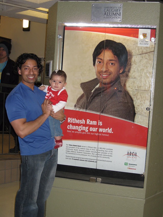 Dr. Ram with his daughter Lalina next to the poster recognizing his University of Calgary Future Alumni Award for leadership